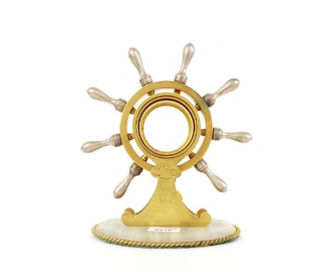 Brass ship's wheel clock/barometer case with aperture for a 2.75" movement, upon an oval onyx base, 10" high