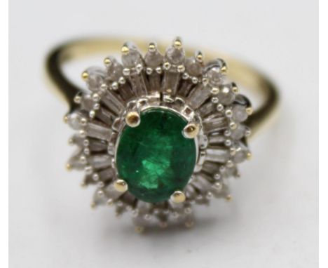 A 9ct gold emerald and diamond cluster ring, the claw set oval stone bordered by baguette and brilliants, size O. 