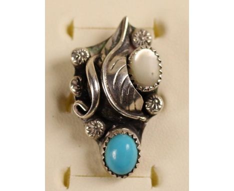 A Navaho silver and turquoise bangle, c.1980's, set with two matrix stones in a floral design, together with a similar ring, 