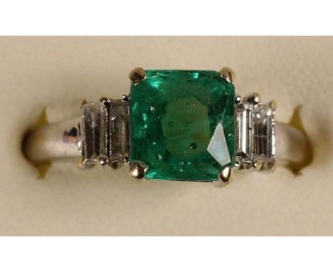 An 18k white gold, emerald and diamond ring, claw set with a step cut stone, stated weight 1.75cts, with baguette shoulders, 