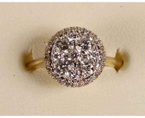 An 18ct gold diamond cluster ring, claw set with brilliant cut stones, bordered by a halo of smaller ones, total weight appro