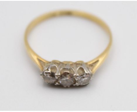 An 18ct gold three stone diamond ring, claw set with brilliant cut stones, total weight approximately 0.35cts, size O. 