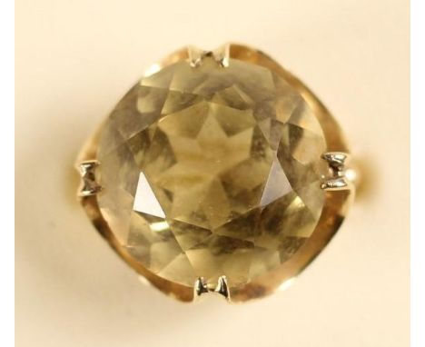 An 18K pale citrine dress ring, claw set with a brilliant cut stone, diameter 16 mm, size K, 7 gms. 