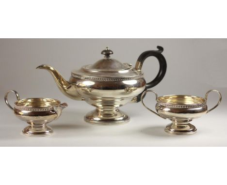 A silver three piece tea service, Birmingham 1931, of pedestal form with gadroon border, 29 oz. 