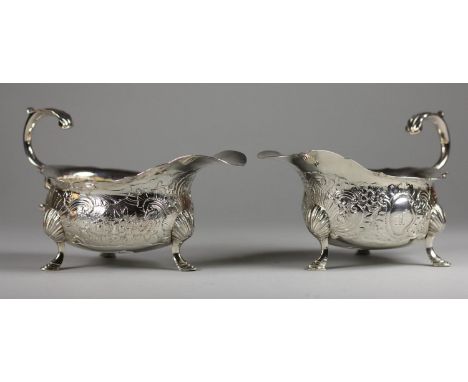 A matched George II and Victorian pair of gravy boats, by ?.K, London 1746 and Thomas Hughes, London 1849, of wavy edge form,