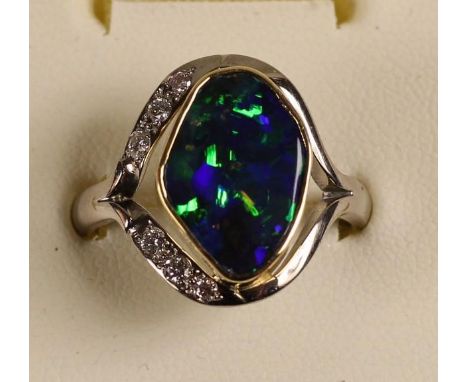 An 18ct white gold Queensland black boulder opal and diamond ring, collet set with an irregular shape stone weighing 8.82 cts