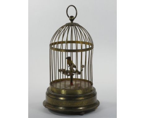 A mid century gilt metal musical automaton, in the form of a bird singing in a cage, stamped Made in Germany, 33 cm. 