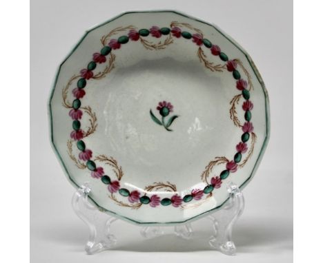 A late Lowestoft porcelain polychrome fluted saucer painted with a central pink flower and a circle of flower heads intertwin