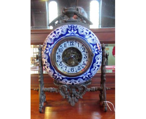 An unusual late Victorian blue and white ceramic circular mantle clock, French movement, mounted to a pierced scrollwork fram