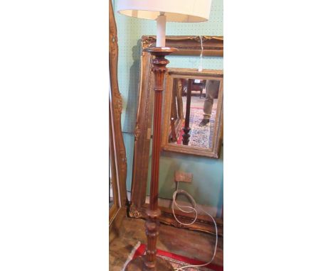 An oak standard lamp, having reeded column over circular foot, 185cm to include shade.
