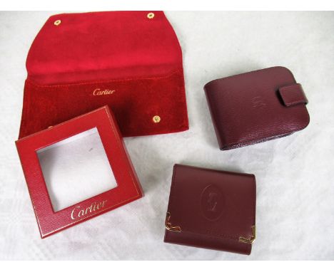 A red leather Cartier purse in original box, unused, together with a further Cartier compact leather case (some use) and a Ca