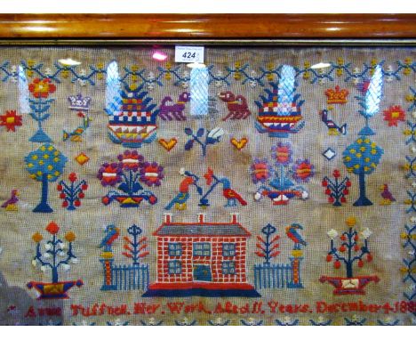 A late Victorian tapestry sampler, completed by Annie Tuffnell, aged 11 years, December 1886, depicting stylized flowers, ani