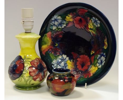 A Moorcroft orchid pattern bowl; a small pomegranate pattern ovoid vase (af); a \Moorcroft anemone pattern table lamp (af) (3