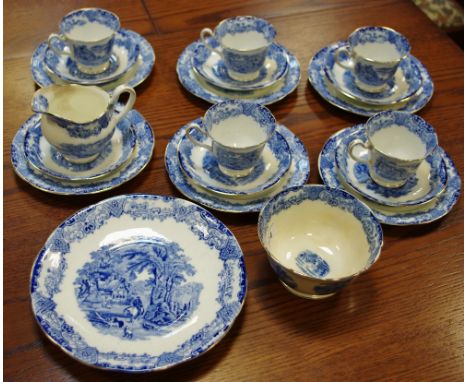 An English porcelain tea service decorated with country scenes, gilt borders comprising teacups, saucers, plates, milk and su