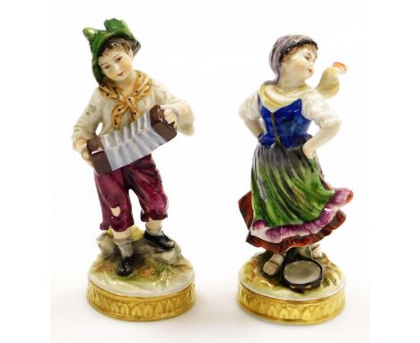 Two 19thC German porcelain figures, of a young boy with accordion and girl with tambourine, on circular gilt highlighted base