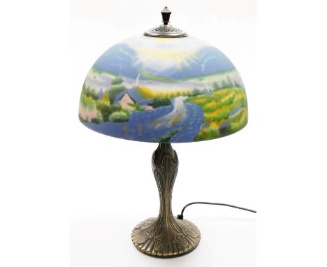 A Thomas Kinkade table lamp, the reverse decorated shade decorated with a field and cottage scene, on a cast metal base, 57cm