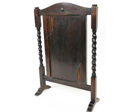 An Art Deco style oak firescreen, with barley twist sides, on stepped scroll feet, 72cm high. 
