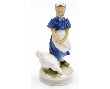 A Royal Copenhagen porcelain figure of a young girl with goose, on a circular base, green printed mark and blue wave mark to 