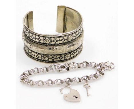 Two silver bracelets, to include a silver bangle, of hammered eastern design, and a silver charm bracelet, with two charms an