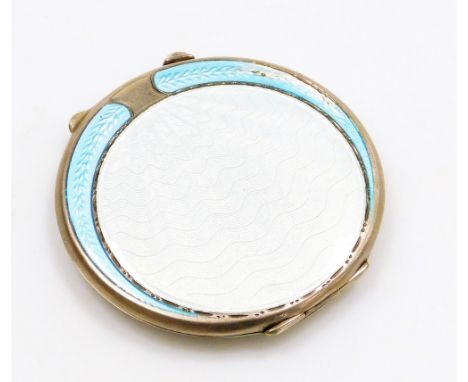 A silver and enamel compact, the front with pale blue enamel detailing, with central circle shield, with two outer fanned dec