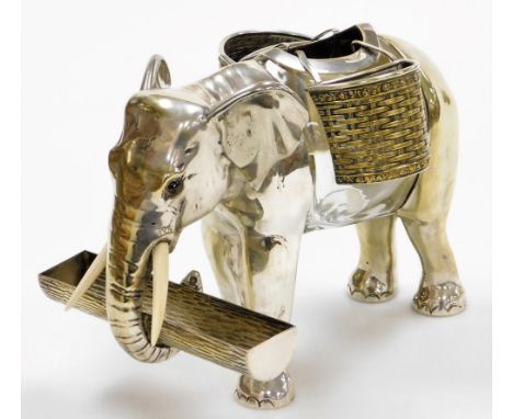 An early 20thC silver plated and glass centrepiece or posy holder, in the form of an elephant, with ivory tusks and glass eye