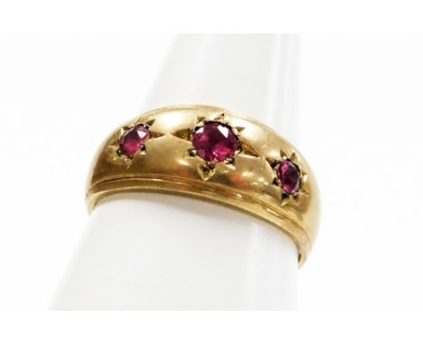 A 9ct gold three stone set dress ring, set with three rubies each in star setting, ring size S½, 3.7g all in.