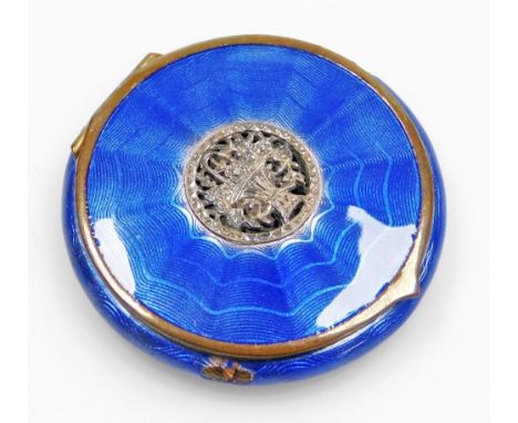 An early 20thC blue guilloche enamel decorated powder compact, with a silver coloured metal flower basket inset to the lid, w