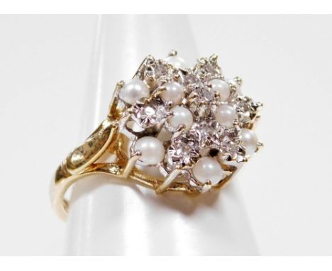 A 9ct gold dress ring, with central cluster design, set with seed pearls and cz stones, with star point decoration on a raise