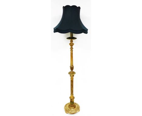 A heavily carved giltwood lamp standard, with turquoise shade on turned stem and circular base, terminating in compressed bun