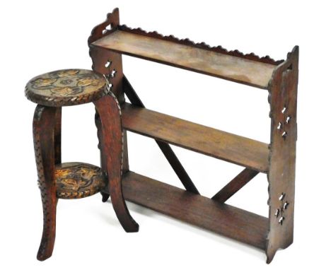 A heavily carved and pokerwork stand, of small proportion, the circular top set with leaves, raised on triple sabre legs join