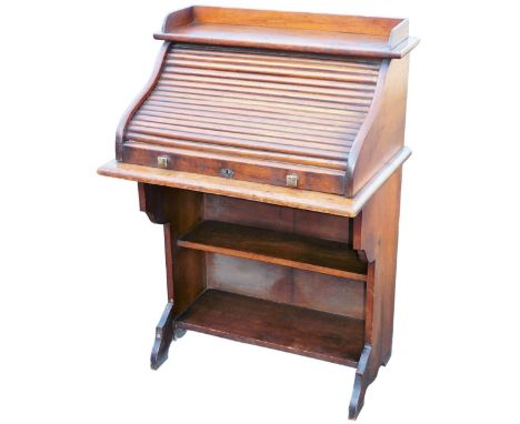 A 1920s oak tambour fronted single writing desk, of small proportion, the three part galleried top raised above a part fitted