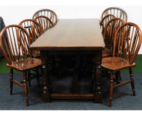 A 19thC style oak refectory table and eight (6+2) hoop back chairs, each chair with stick backs, turned single orb front legs