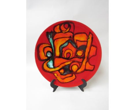 A Poole Delphis large plate in reds, orange and green. 35cm diameter. Decorators mark to back 