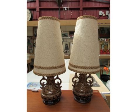 A pair of West German pottery lamp bases with brown and cream glazes, original shades