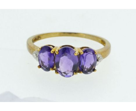 A 9ct gold ring set with three amethysts, size O, 1.6g 