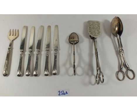 A set of six silver handled tea knives, a silver plated cake fork and three pairs of cake tongs 