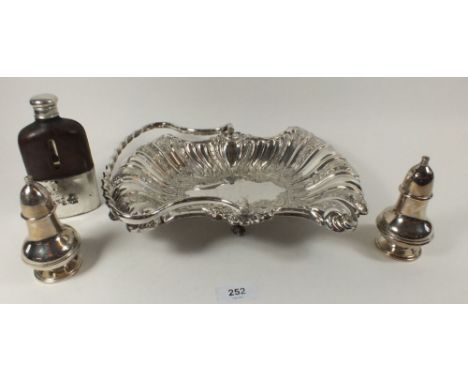 A Victorian silver plated cake basket, two cruets and a spirit flask 