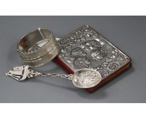 A late Victorian ornate silver bangle (a.f.), a silver mounted day book and a Dutch white metal spoon.