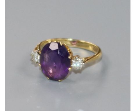 An 18ct gold amethyst and diamond three stone dress ring, size O.