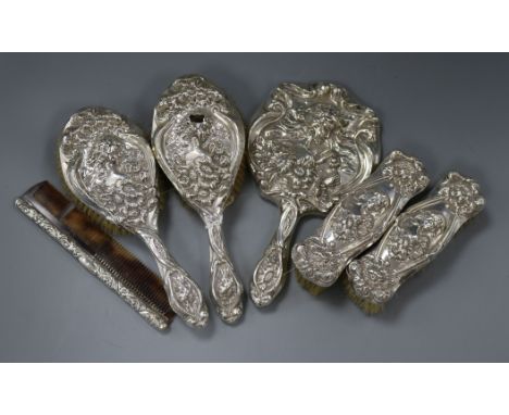 An Edwardian five piece embossed silver mounted dressing table set by Levi &amp; Salaman and a similar mounted comb.