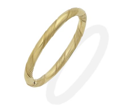 GARRARD: GOLD BANGLE, CIRCA 1985Hinged, mounted in 18 carat gold, rubbed marker's mark G&amp;Co, London import mark, inner ci