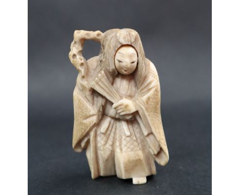 An early 20th century ivory netsuke, depicting a figure holding a fan with rotating head, 5.5cm high 