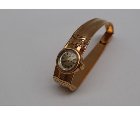 A Lady's 18ct gold Technos wristwatch on an integrated strap, the gilt dial with batons, approximately 29 grams
