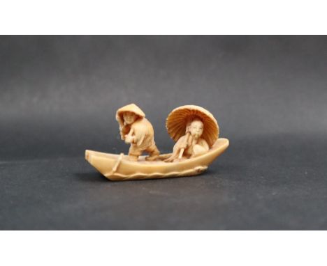 A late 19th / early 20th century netsuke in the form of two figures in a boat, signed to the base, 55mm long