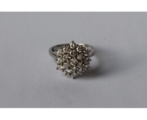 A diamond cluster ring, set with nineteen round brilliant cut diamonds to a white metal setting and shank, size K, approximat