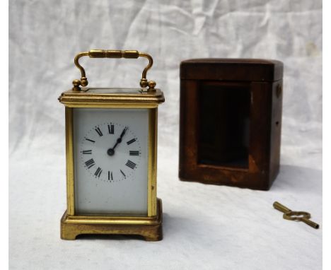 A 19th century brass cased carriage timepiece with an enamel dial and Roman numerals 14.5cm high including handle, in a leath
