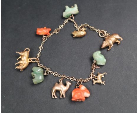 A Chinese yellow metal charm bracelet set with zodiac and other animals including a jade sheep's head, yellow metal doe, cora