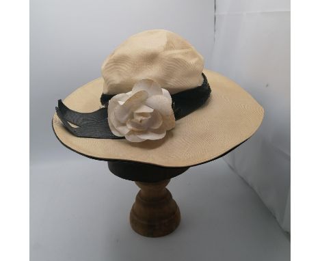 Christian Dior straw hat with black trim and a white flower. 
