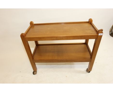 A ROBERT MOUSEMAN THOMPSON OAK TWO-TIER DINNER WAGON, the square supports with carved mouse signature to top, raised on casto