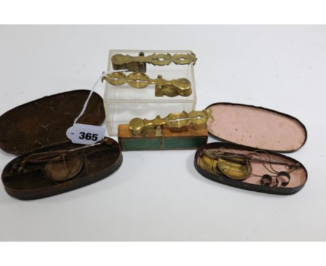 THREE SETS OF BRASS SOVEREIGN BALANCES and two sets of gold scales, in original black tin cases.  (5)   